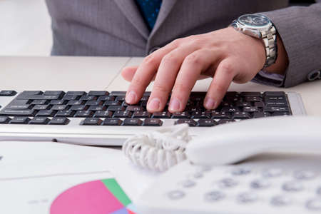 Finance professional working on keyboard with reportsの写真素材