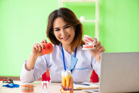 Woman dentist working on teeth implant