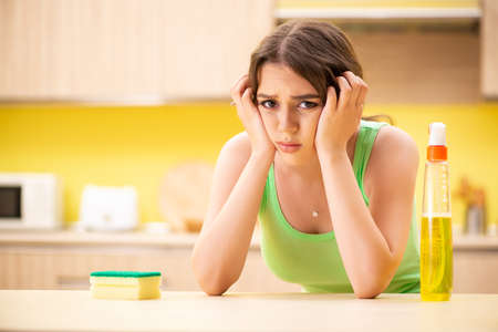 Young beatifull woman polishing table in the kitchenの写真素材