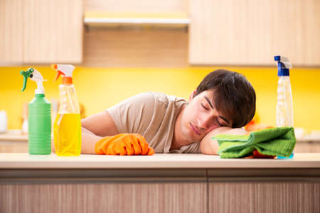 Single man cleaning kitchen at home