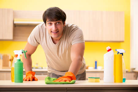 Single man cleaning kitchen at home