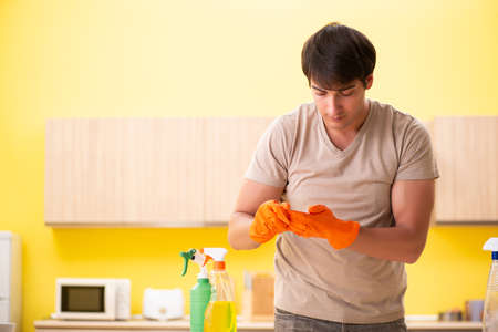 Single man cleaning kitchen at homeの写真素材