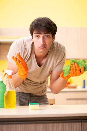 Single man cleaning kitchen at homeの写真素材
