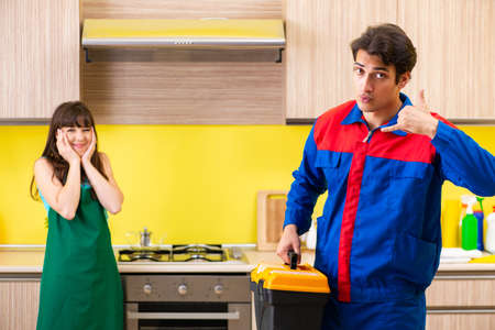 Woman with contractor at kitchen discussing repairの写真素材