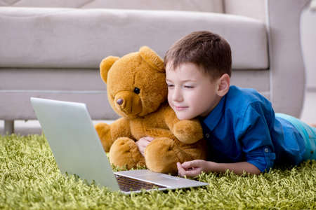 Little boy surfing internet on laptop