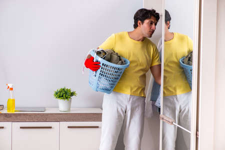 Young handsome man cleaning in the bedroomの写真素材