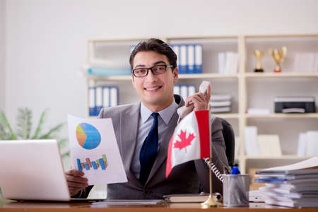Businessman with Canadian flag in officeの写真素材