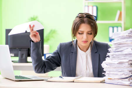 Young female employee very busy with ongoing paperworkの写真素材