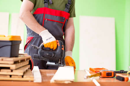 Young man carpenter working in workshop