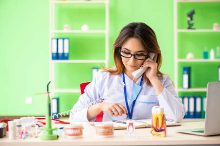 Woman dentist working on teeth implantの写真素材