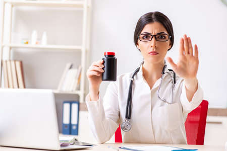 Woman doctor with bottle of medicinesの写真素材
