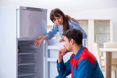 Man repairing fridge with customerの写真素材