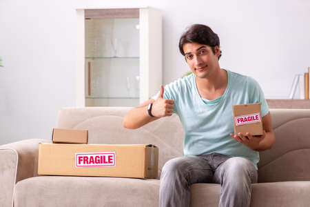 Man opening fragile parcel ordered from internetの写真素材