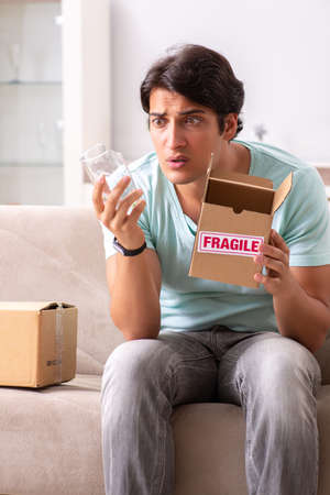 Man opening fragile parcel ordered from internetの写真素材