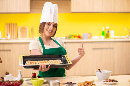 Young cook cooking cakes in the kitchenの写真素材