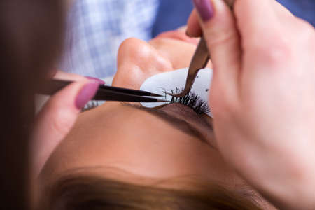 Young woman getting eyelash extension