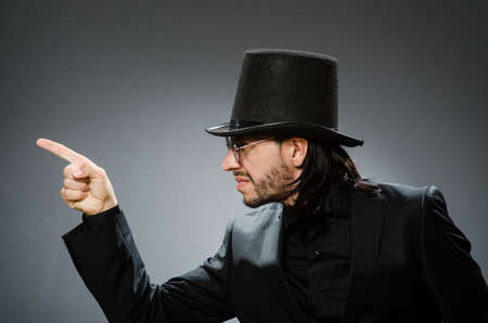 Vintage concept with man wearing black top hat and finger pointing to his right