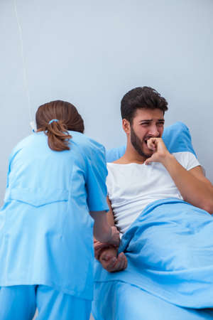 Woman doctor examining male patient in hospital