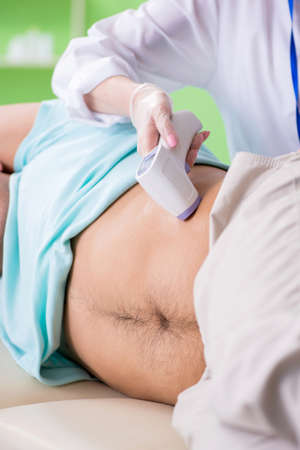 Young man visiting radiologyst for ultrasound procedureの写真素材