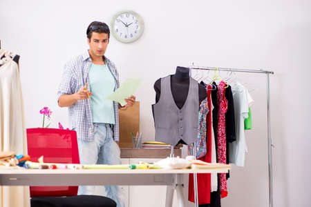 Young handsome tailor working in his workshopの写真素材