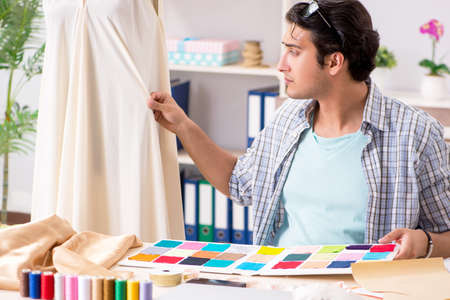Young handsome tailor working in his workshopの写真素材