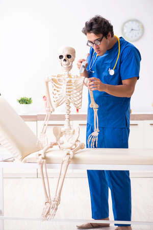 Funny doctor with skeleton in hospitalの写真素材