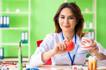 Woman dentist working on teeth implant