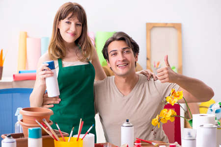 Couple decorating pots in workshop during class