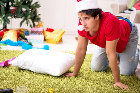 Young man drunk at home after christmas partyの写真素材