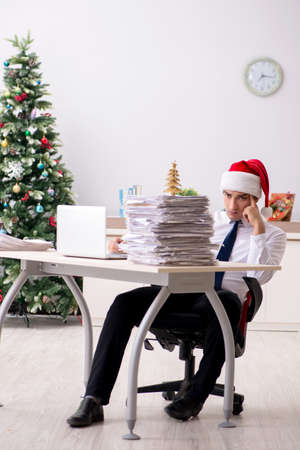 Young worker working in office on christmas shiftの写真素材