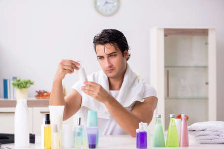 Young handsome man in the bathroom in hygiene conceptの写真素材