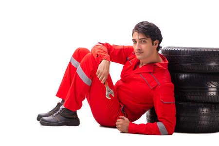 Young garage worker with tyre isolated on whiteの写真素材