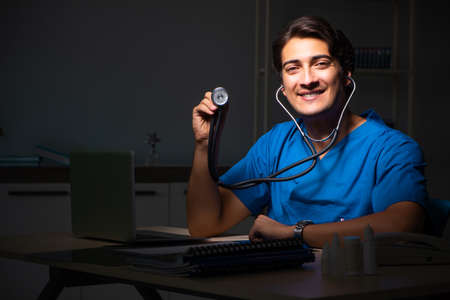 Young handsome doctor working night shift in hospitalの写真素材