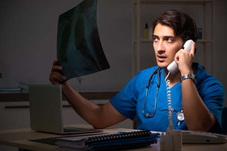 Young handsome doctor working night shift in hospital