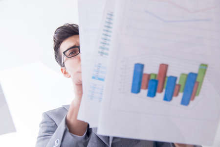 Businessman looking at financial charts and graphsの写真素材