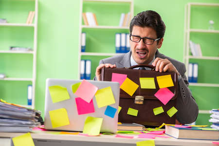 Businessman unhappy with many conflicting priorities sitting inの写真素材