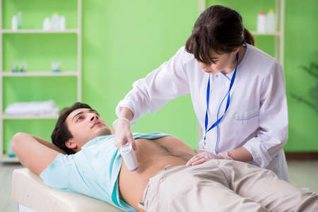 Young man visiting radiologyst for ultrasound procedureの写真素材