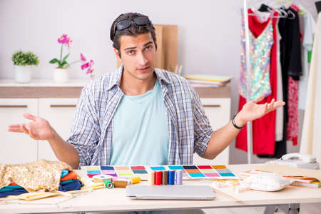 Young handsome tailor working in his workshopの写真素材