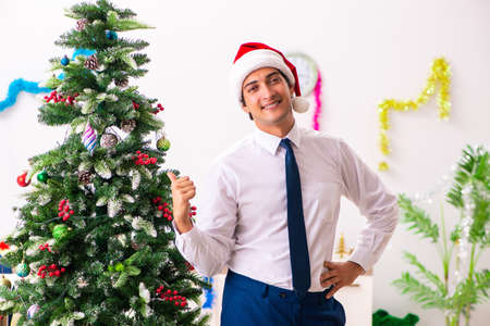 Employee businessman celebrating christmas in officeの写真素材