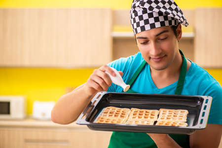 A man preparing waffle in kitchen at homeの写真素材