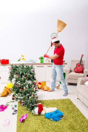Man cleaning his apartment after christmas partyの写真素材