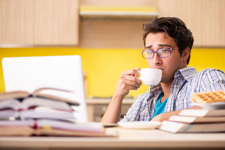 Student preparing for exam sitting at the kitchenの写真素材