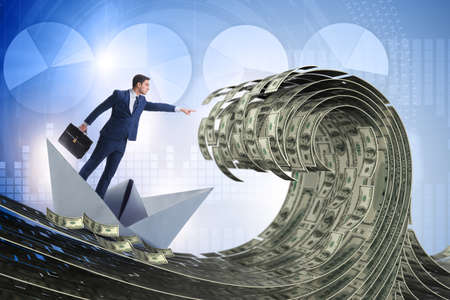 Businessman riding paper boat in dollar seaの写真素材