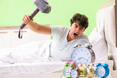 Young man having trouble waking up in early morningの写真素材