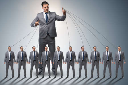 Boss employee manipulating his staff in business conceptの写真素材