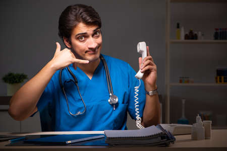 Young handsome doctor working night shift in hospitalの写真素材
