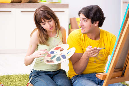Young couple enjoying painting at homeの写真素材