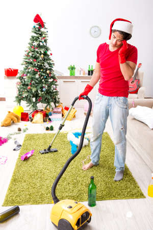 Man cleaning his apartment after christmas partyの写真素材