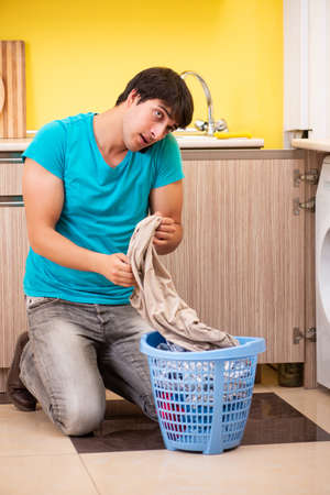Young husband man doing laundry at homeの写真素材