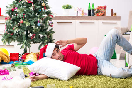 Young man drunk at home after christmas partyの写真素材